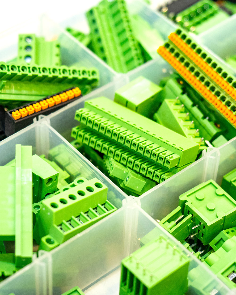 Plastic components and green electrical connectors used in industrial plastics manufacturing.