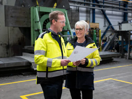 Jernbro employees talking in a factory environment